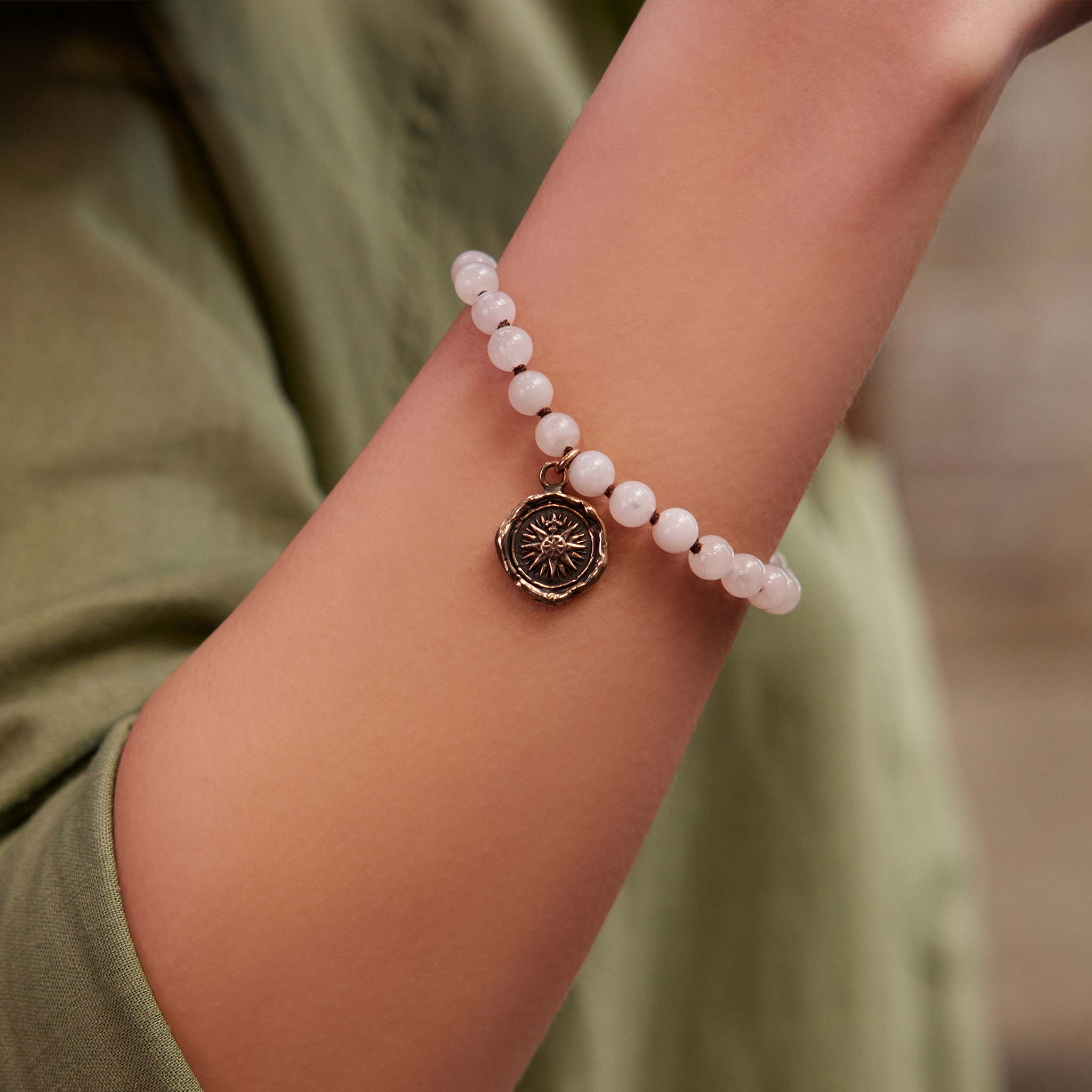 A closeup of a model's wrist wearing our Honeybee Beaded Talisman Bracelet.