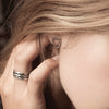 A close up of a model wearing our Extra Small Open Shield Studs.