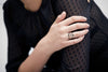 A close up of a models hand wearing our Ab Hinc (From Here On) Narrow 14K Gold Textured Band Ring