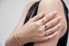 A woman modeling our 14 karat gold handcrafted Hand and Heart signet ring