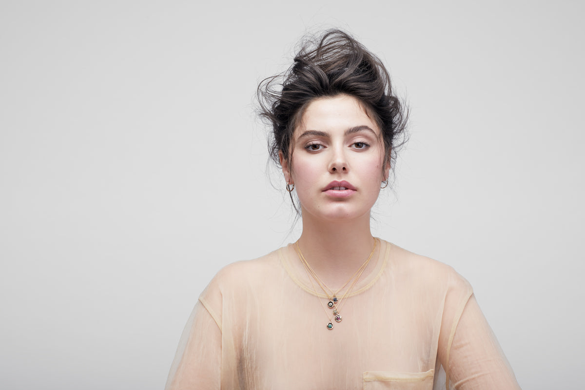A model wearing our Large Ruby 14K Gold Faceted Stone Necklace.