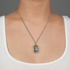 A close up of a model wearing Pyrrha's sterling silver Whole Hearted talisman on a silver chain.