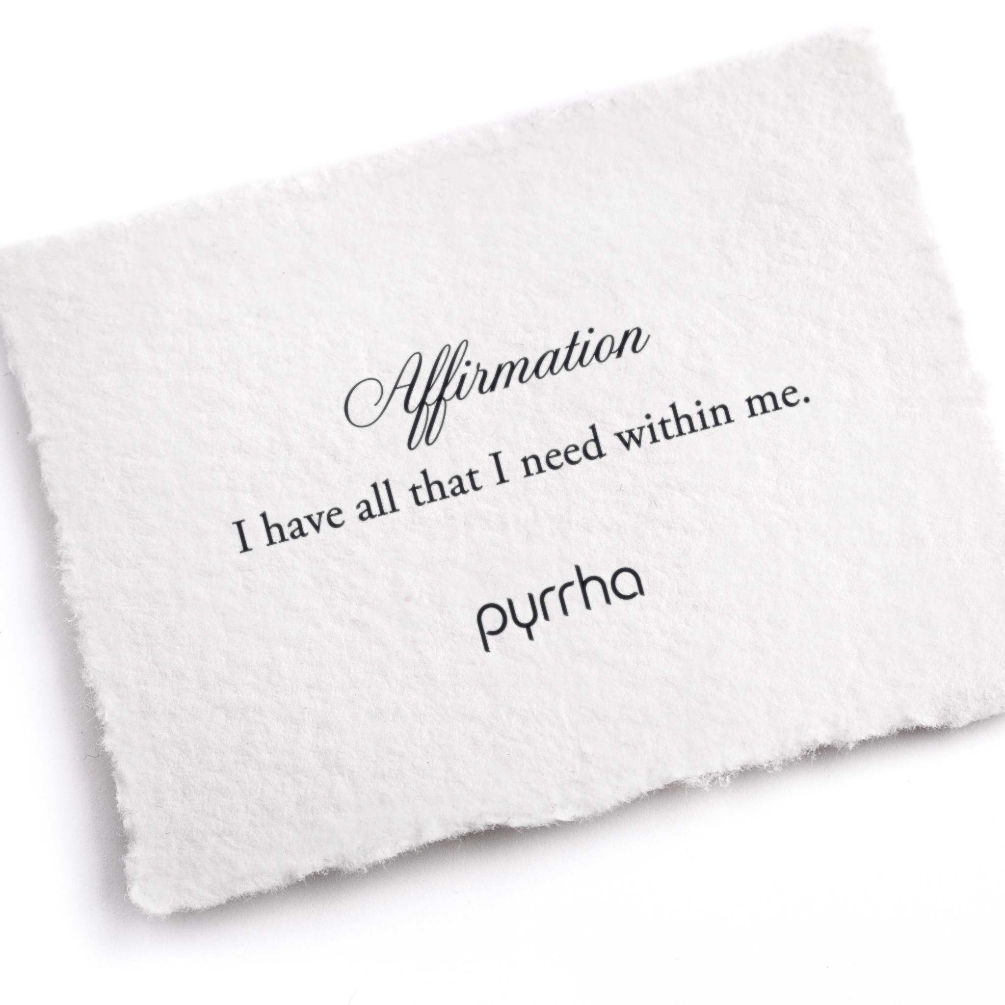 A hand-torn, letterpress printed card describing the meaning for Pyrrha's I Have All That I Need Within Me Affirmation Talisman Necklace