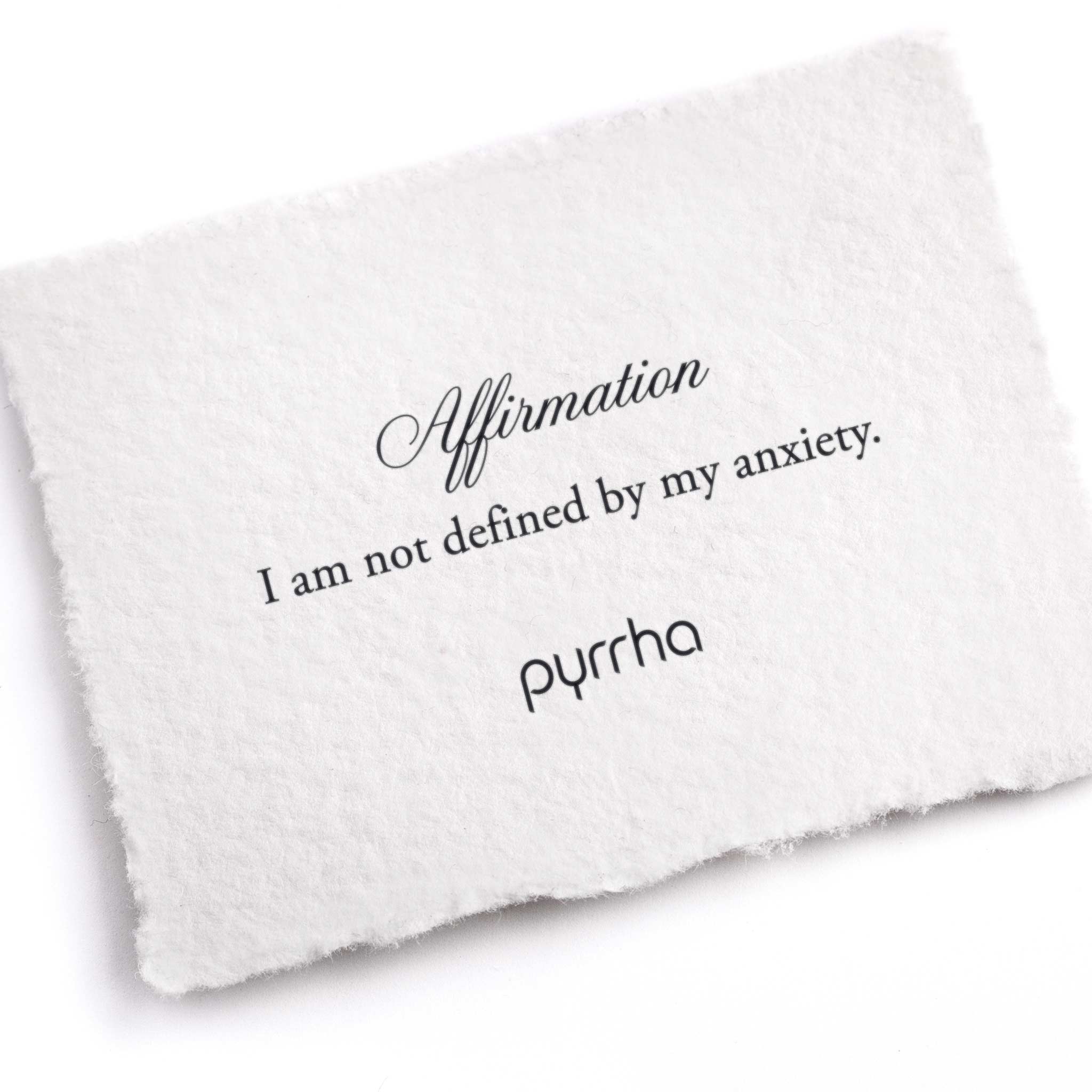 A hand-torn, letterpress printed card describing the meaning for Pyrrha's I Am Not Defined By My Anxiety Affirmation Talisman Necklace