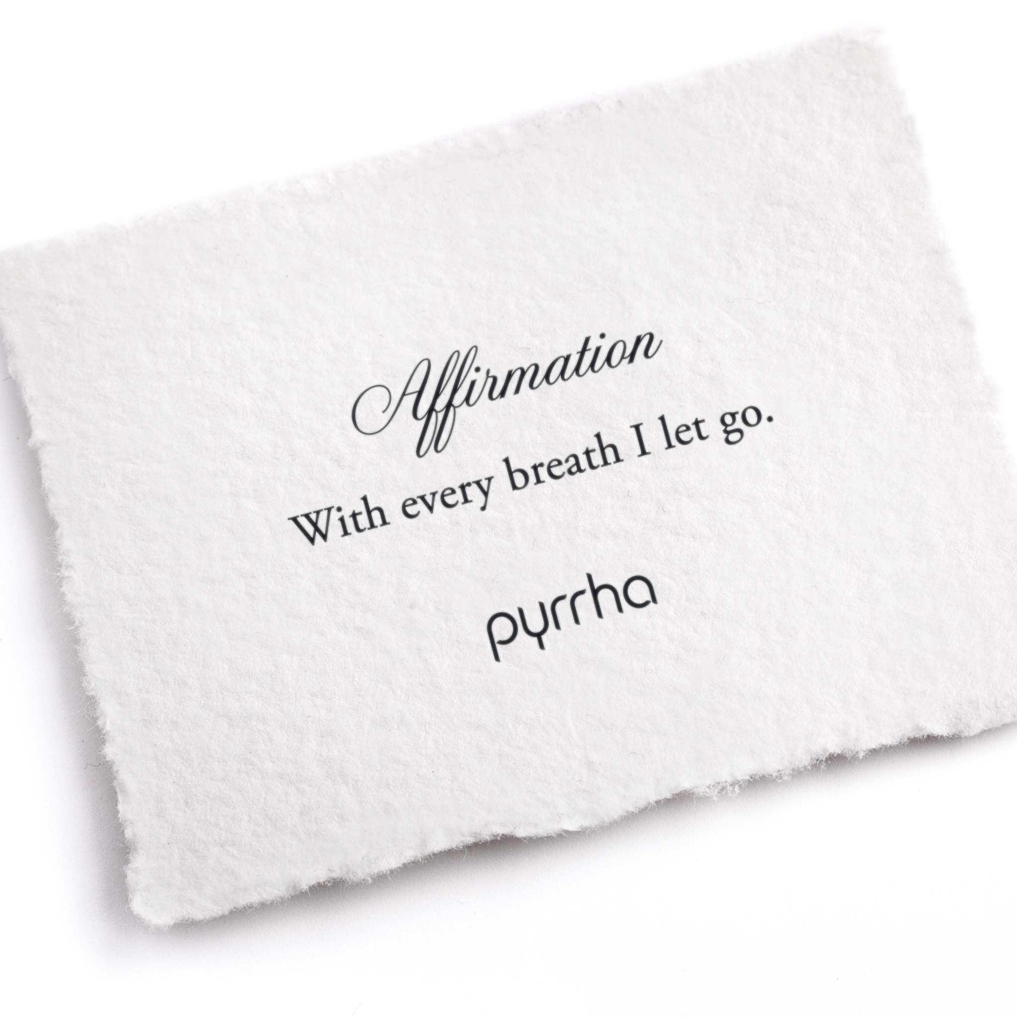 A hand-torn, letterpress printed card describing the meaning for Pyrrha's With Every Breath I Let Go Affirmation Talisman Necklace