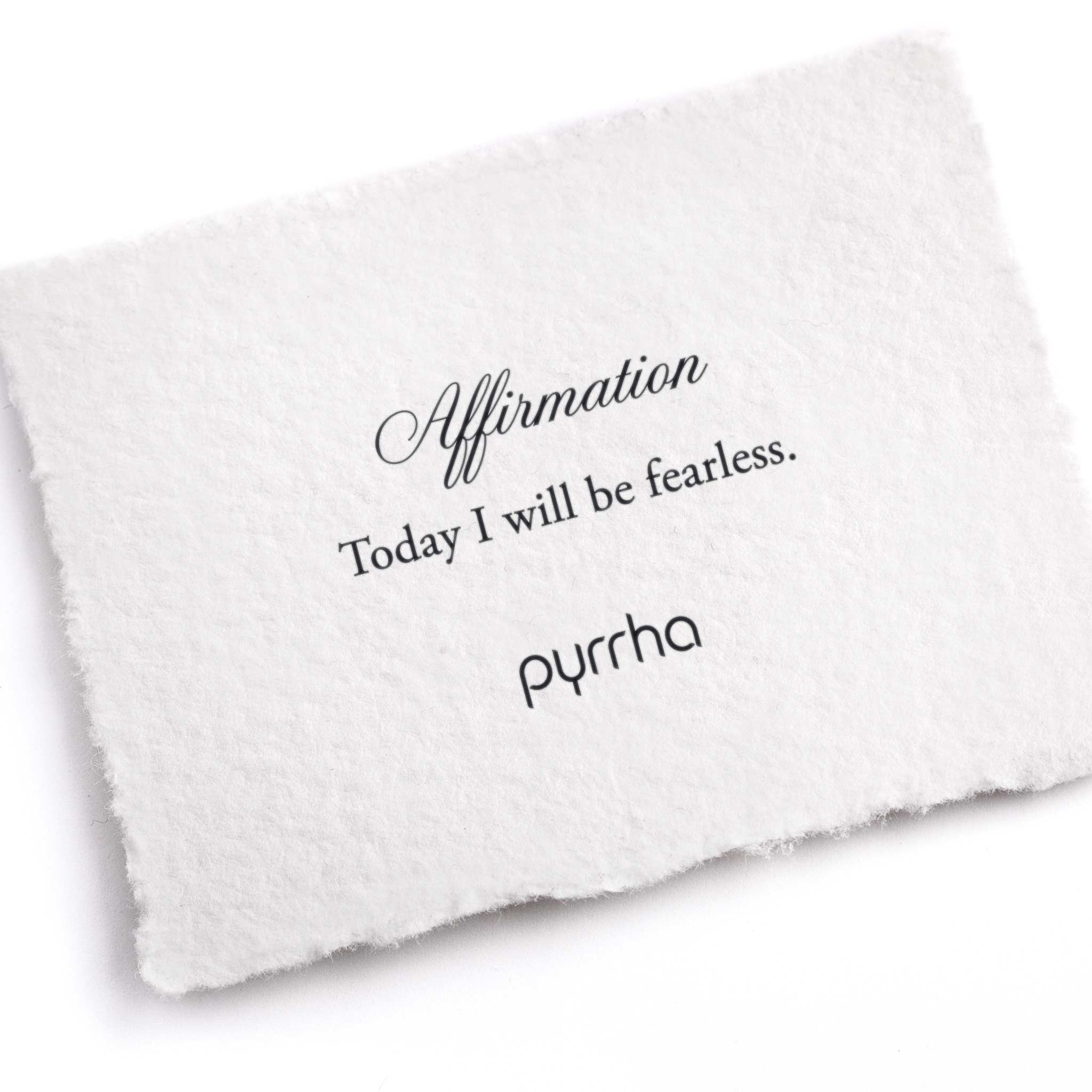 A hand-torn, letterpress printed card describing the meaning for Pyrrha's Today I Will Be Fearless Affirmation Talisman Necklace