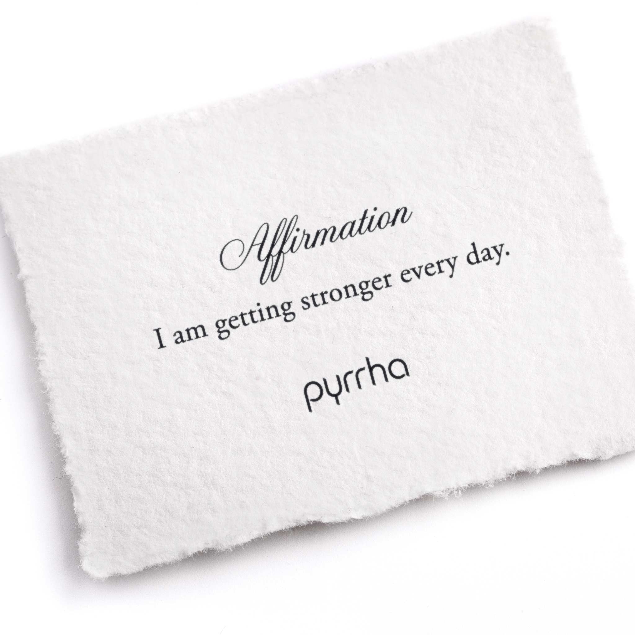 A hand-torn, letterpress printed card describing the meaning for Pyrrha's I Am Getting Stronger Every Day Affirmation Talisman Necklace