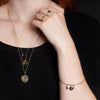 A close up of a model wearing our Cancer 14K Gold Zodiac Charm.