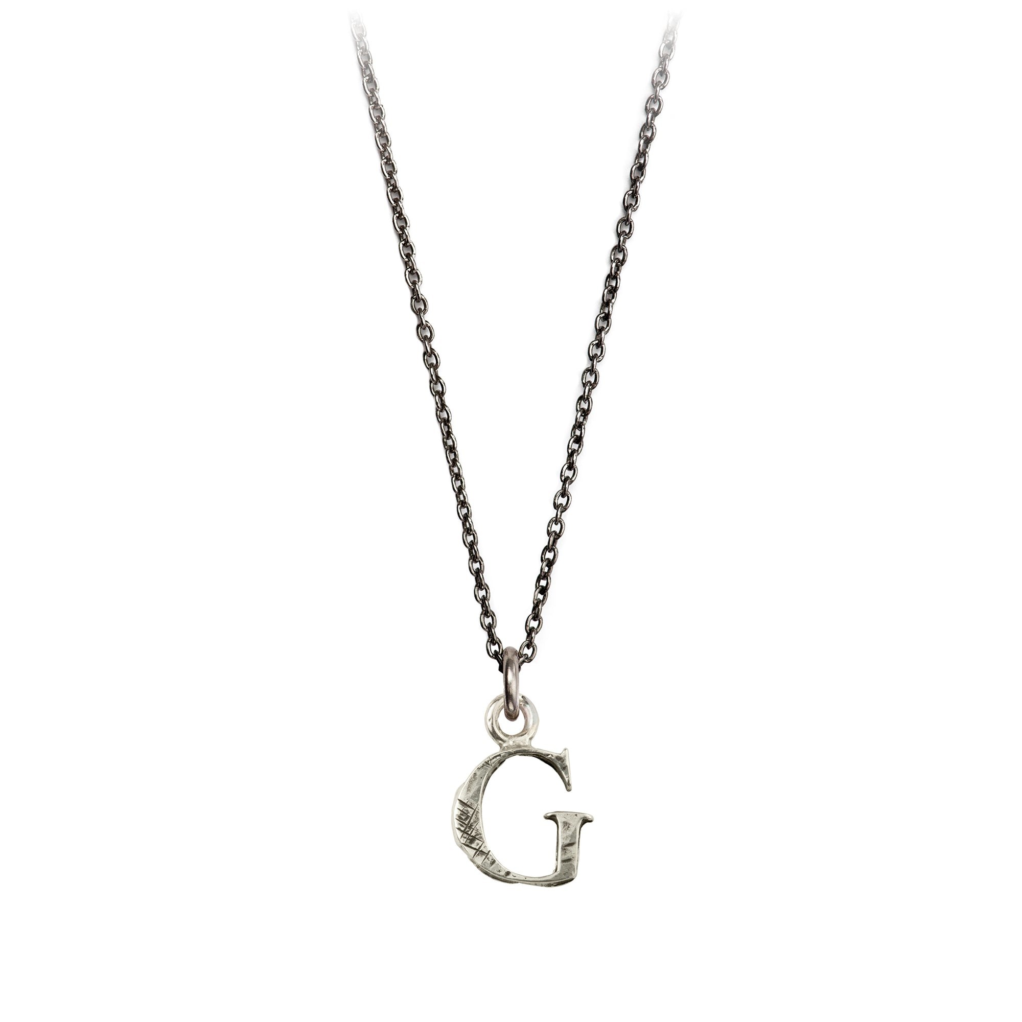 A sterling silver letter "G" charm on a silver chain.