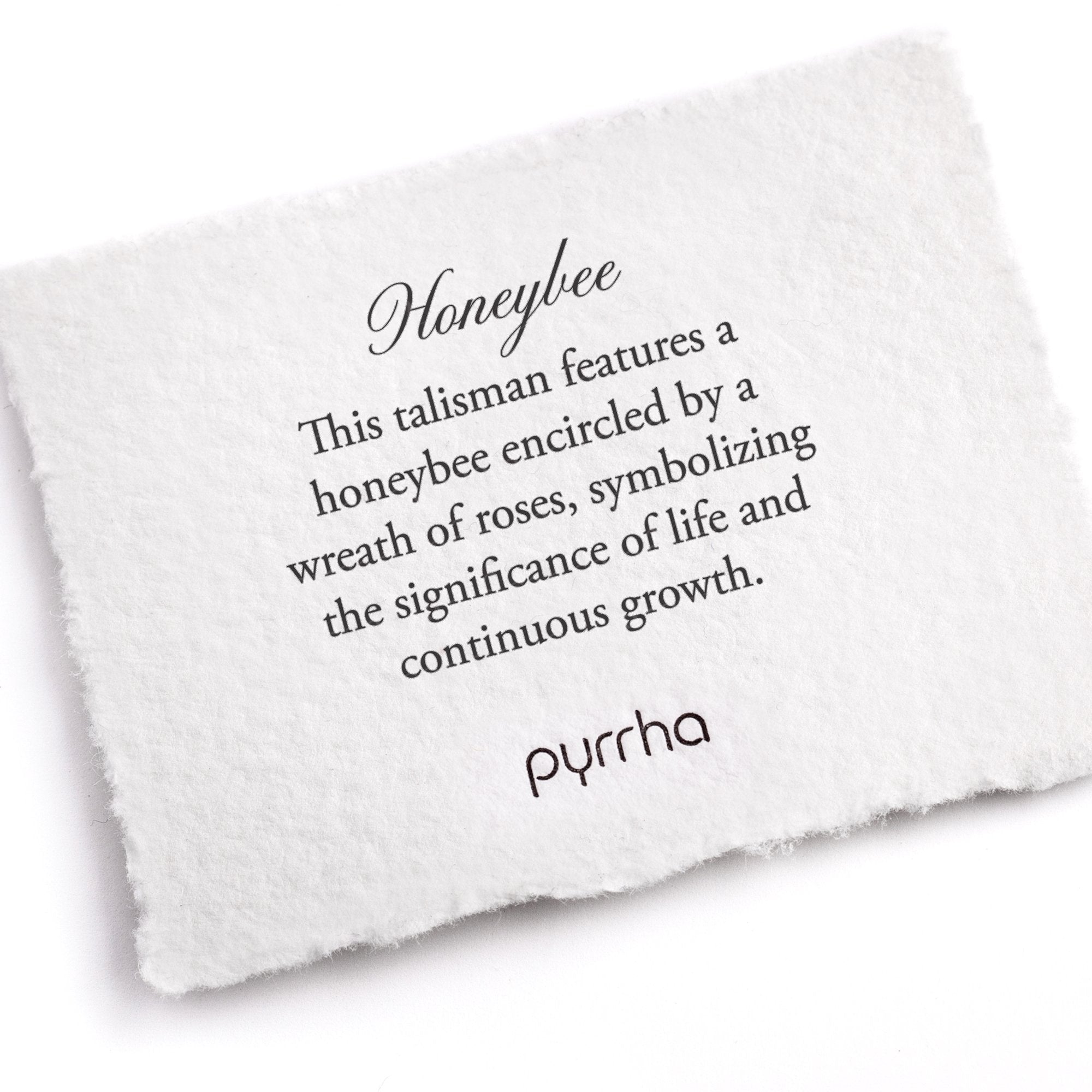 A hand-torn, letterpress printed card describing the meaning for Pyrrha's Honeybee Talisman Necklace