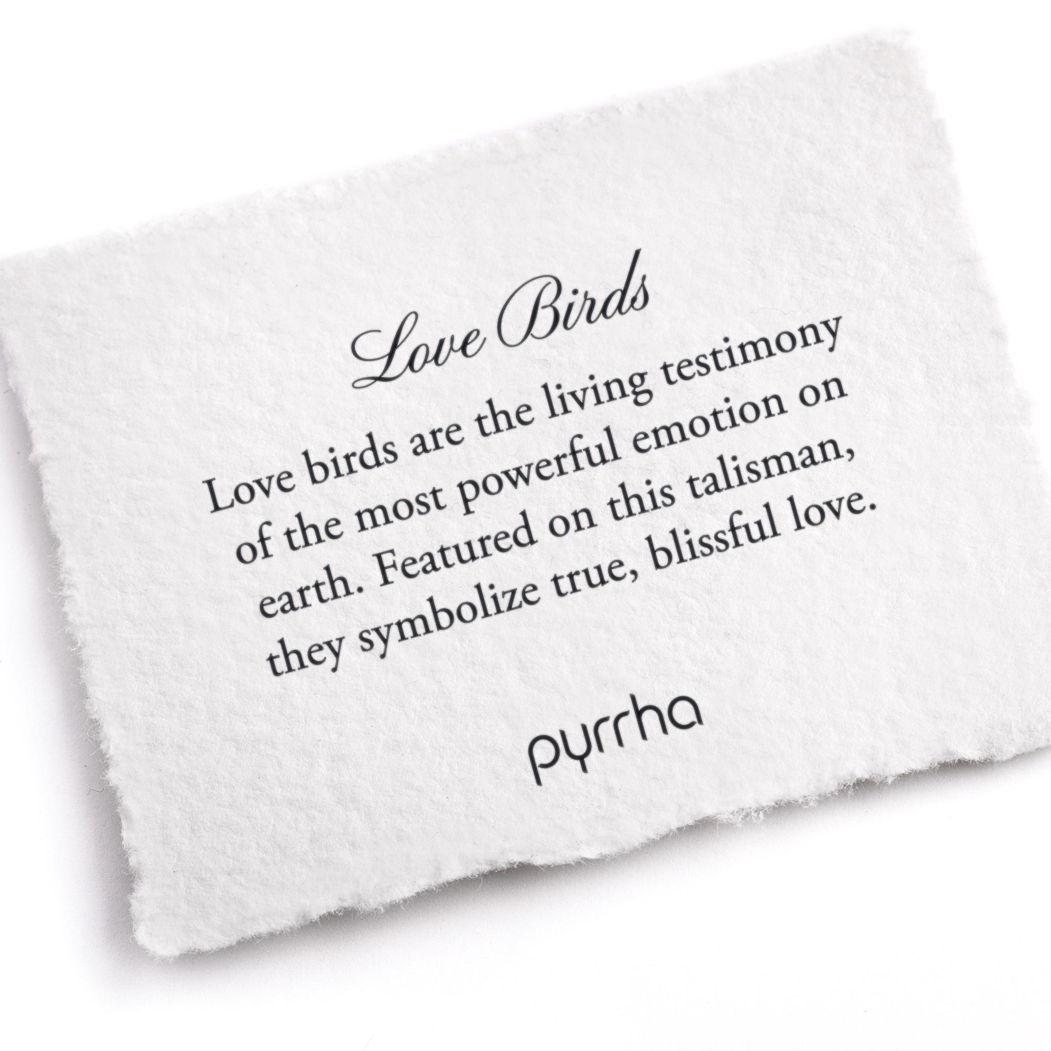 A hand-torn, letterpress printed card describing the meaning for Pyrrha's Love Birds 14K Gold Talisman