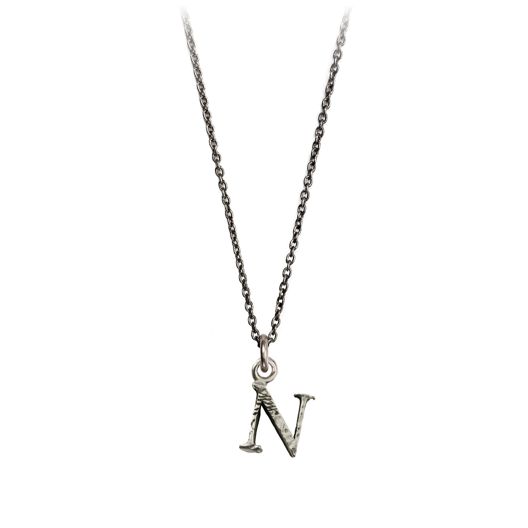 A sterling silver letter "N" charm on a silver chain.