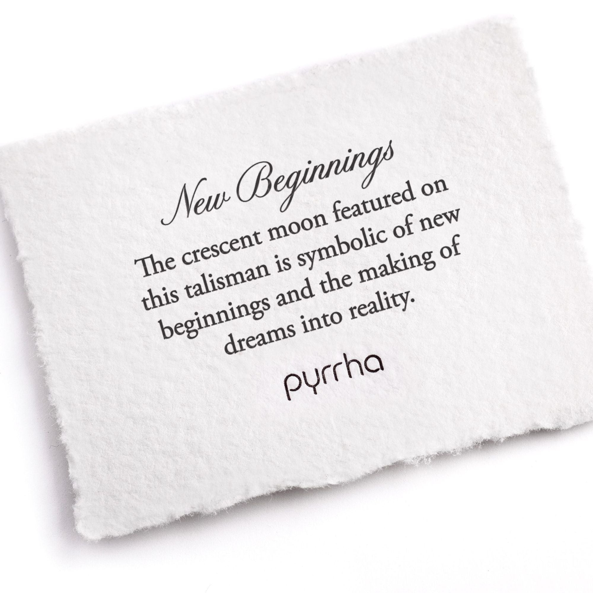 A hand-torn, letterpress printed card describing the meaning for Pyrrha's New Beginnings 14K Gold Talisman