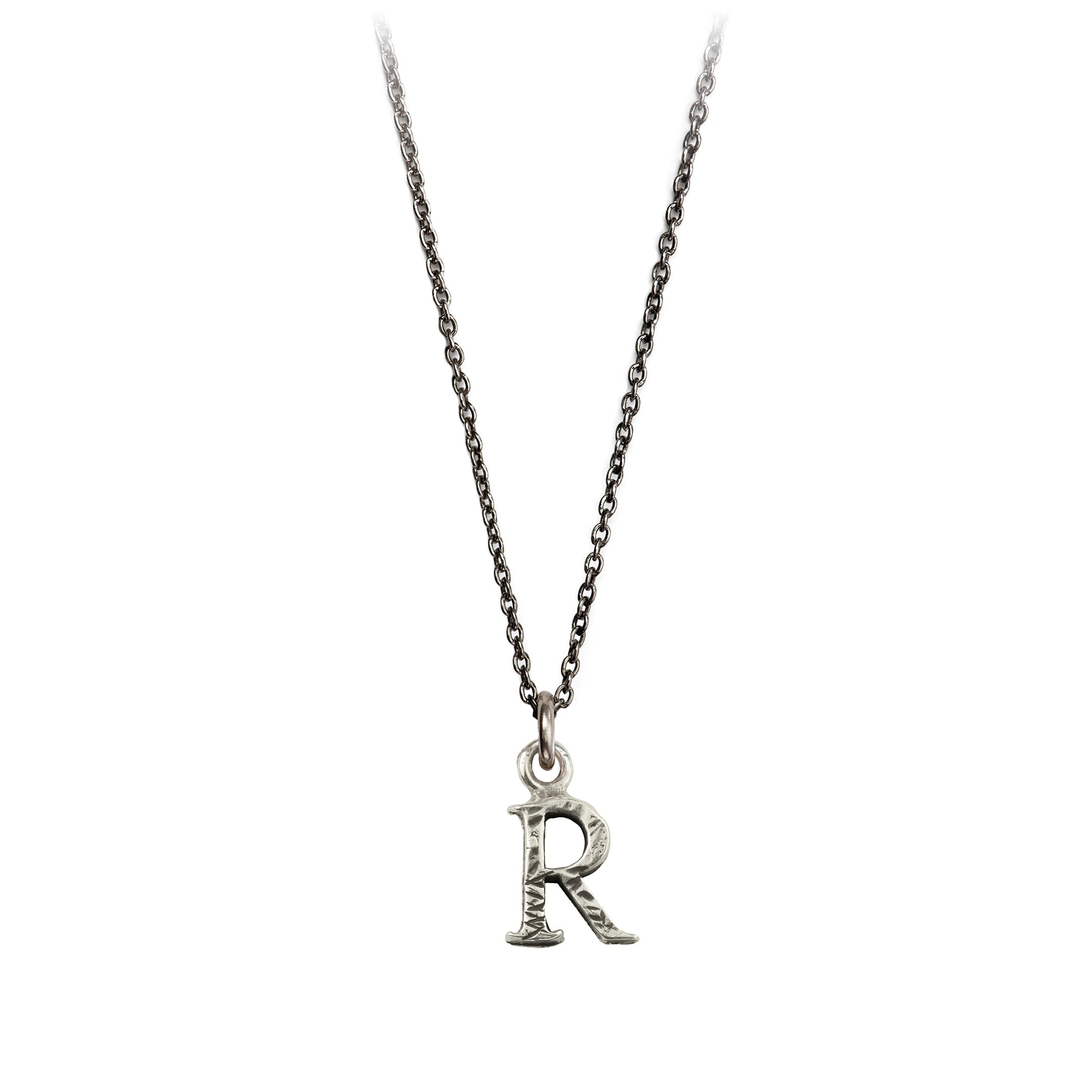 A sterling silver letter "R" charm on a silver chain.