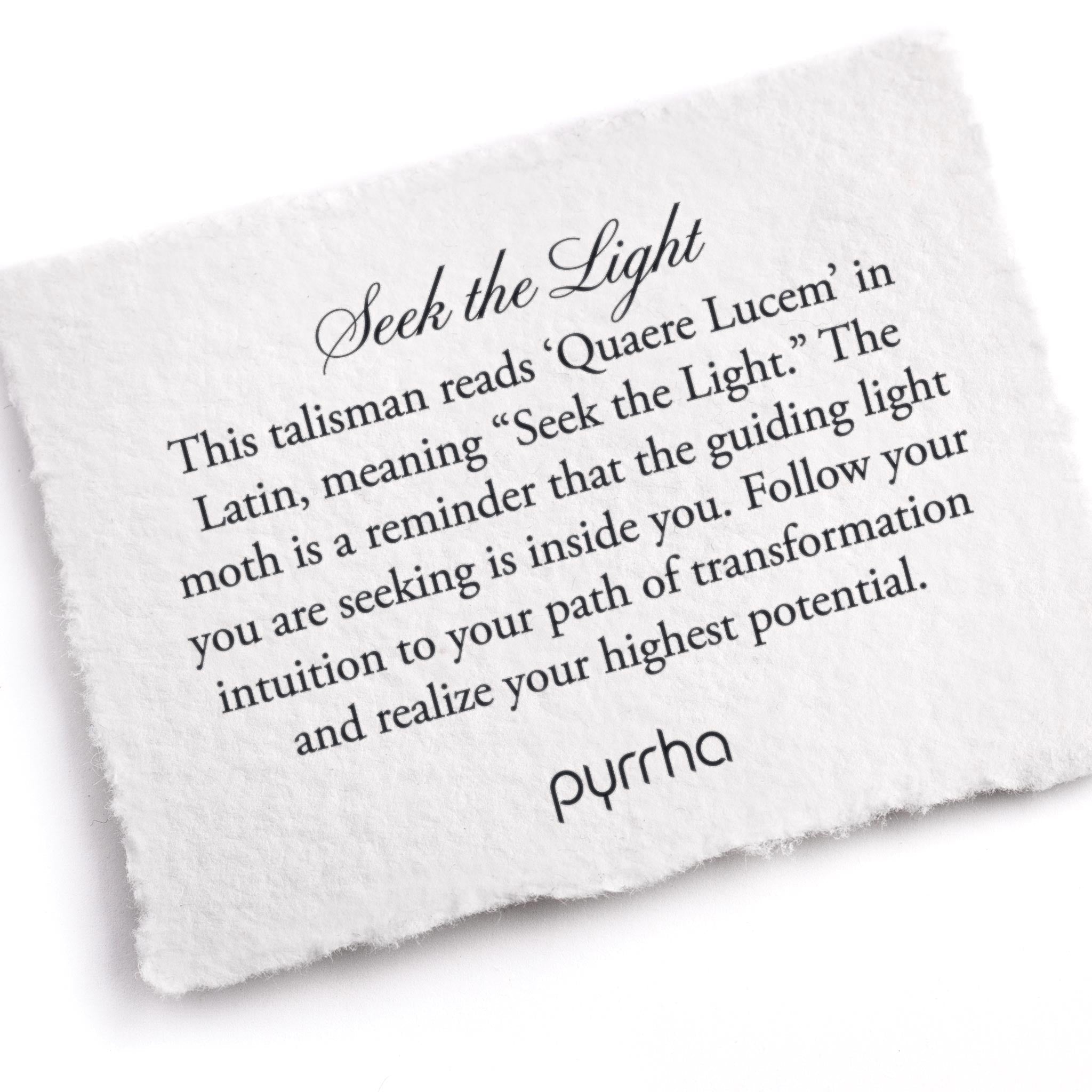 A hand-torn, letterpress printed card describing the meaning for Pyrrha's Seek The Light Signature Talisman Necklace