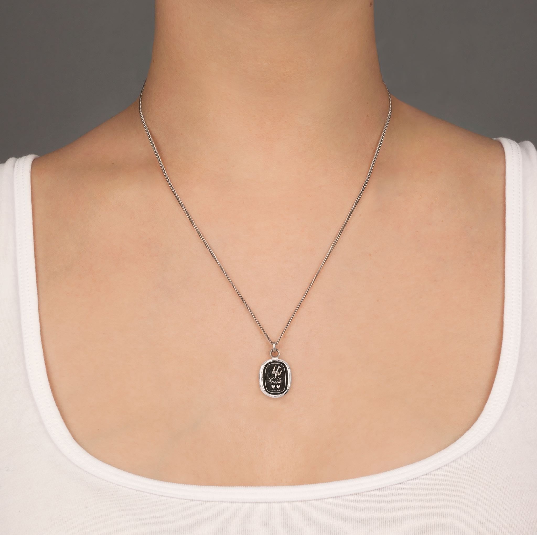 A close up of a model wearing Pyrrha's soul mates talisman on a Oxidized Silver chain.