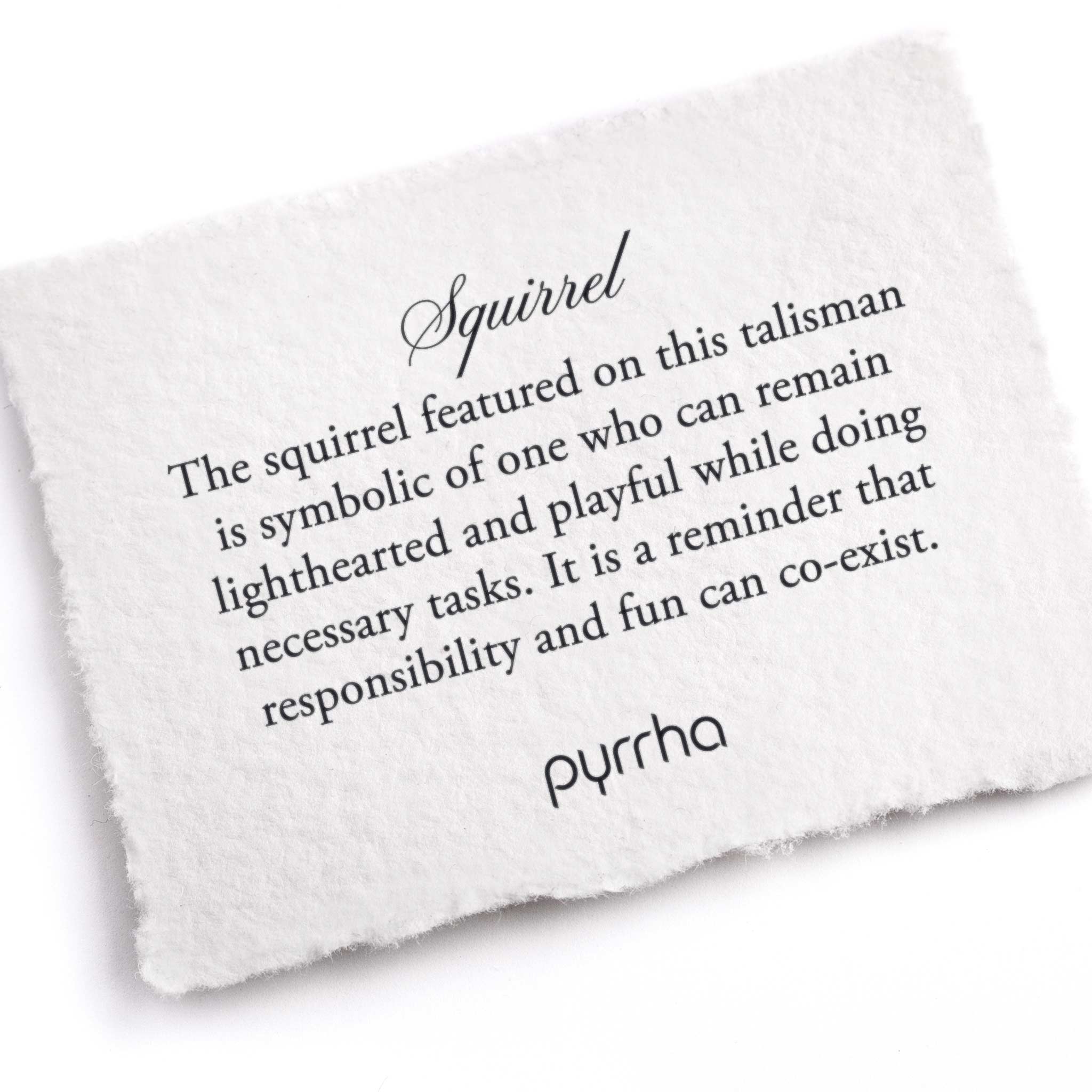 A hand-torn, letterpress printed card describing the meaning for Pyrrha's Squirrel 14K Gold Talisman