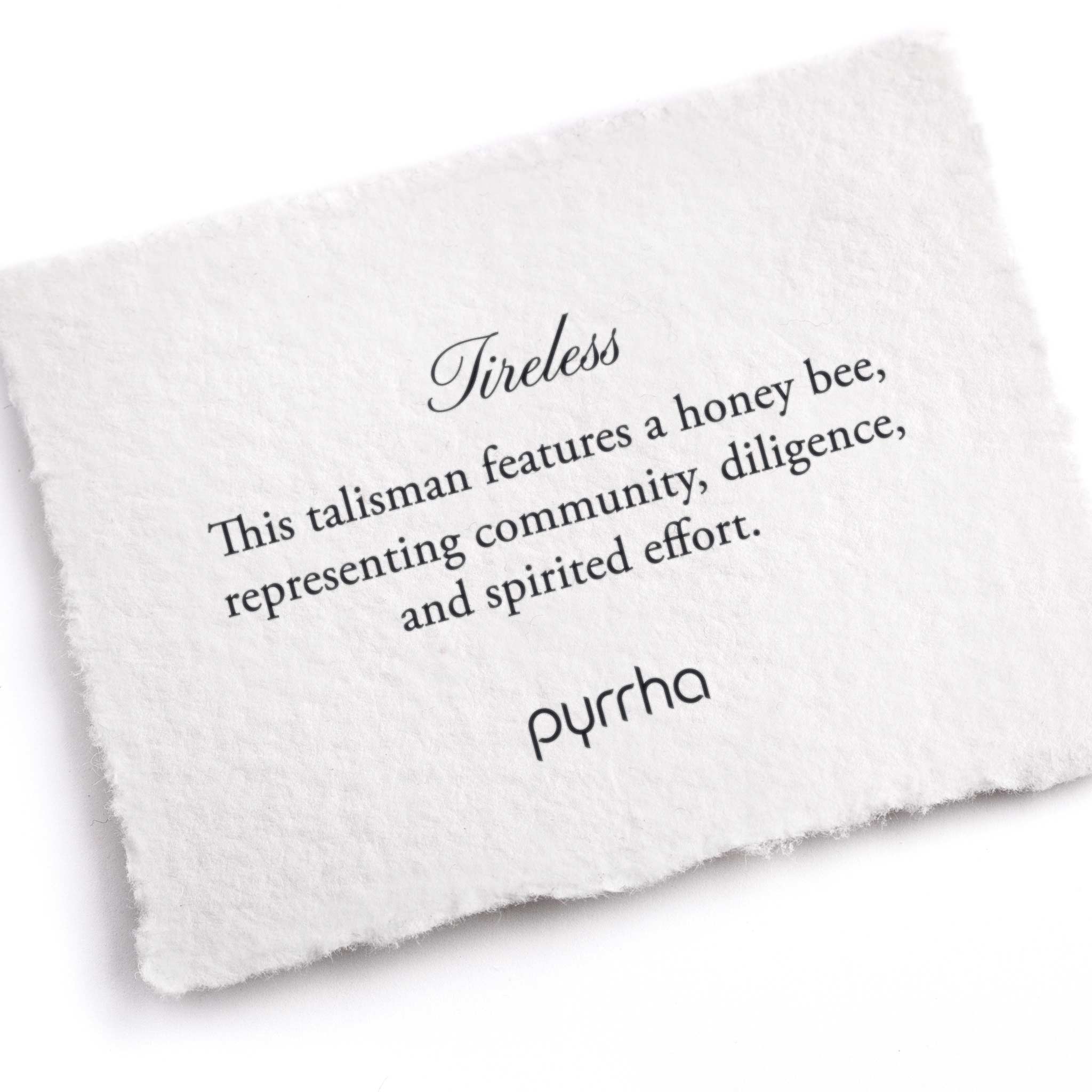 A hand-torn, letterpress printed card describing the meaning for Pyrrha's Tireless Talisman 