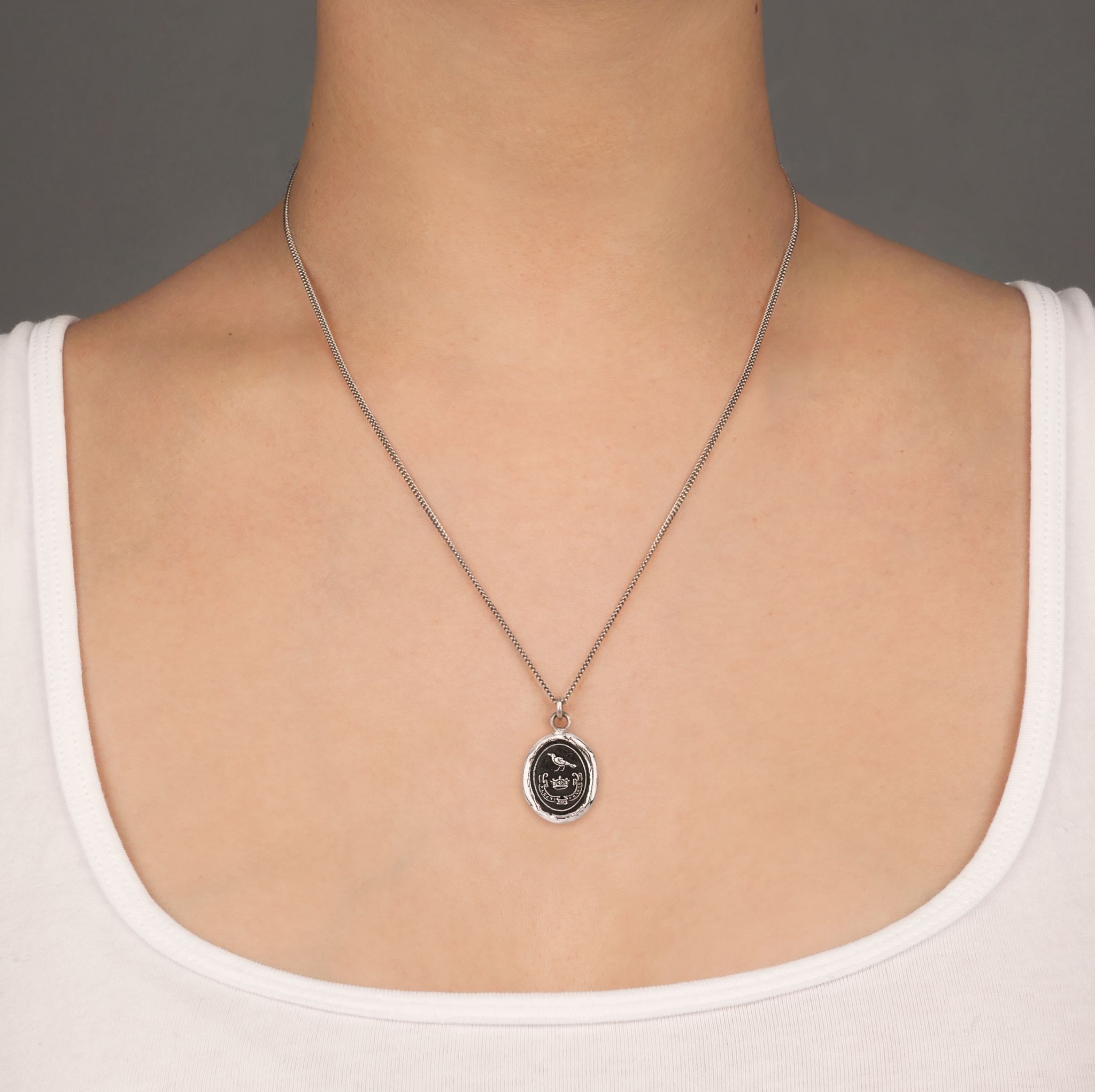 A close up of a model wearing Pyrrha's unbreakable talisman on a Oxidized Silver chain.